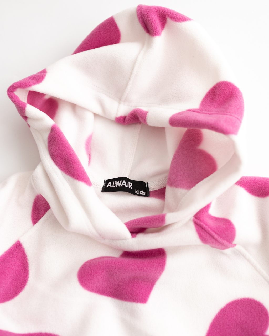 Close-up of hood with Alwair Kids label on white fleece hoodie