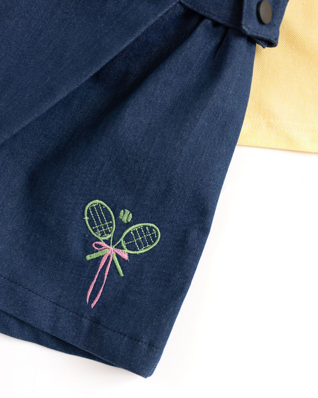 Close-up of embroidered tennis rackets on navy girls skort by Alwair Kids