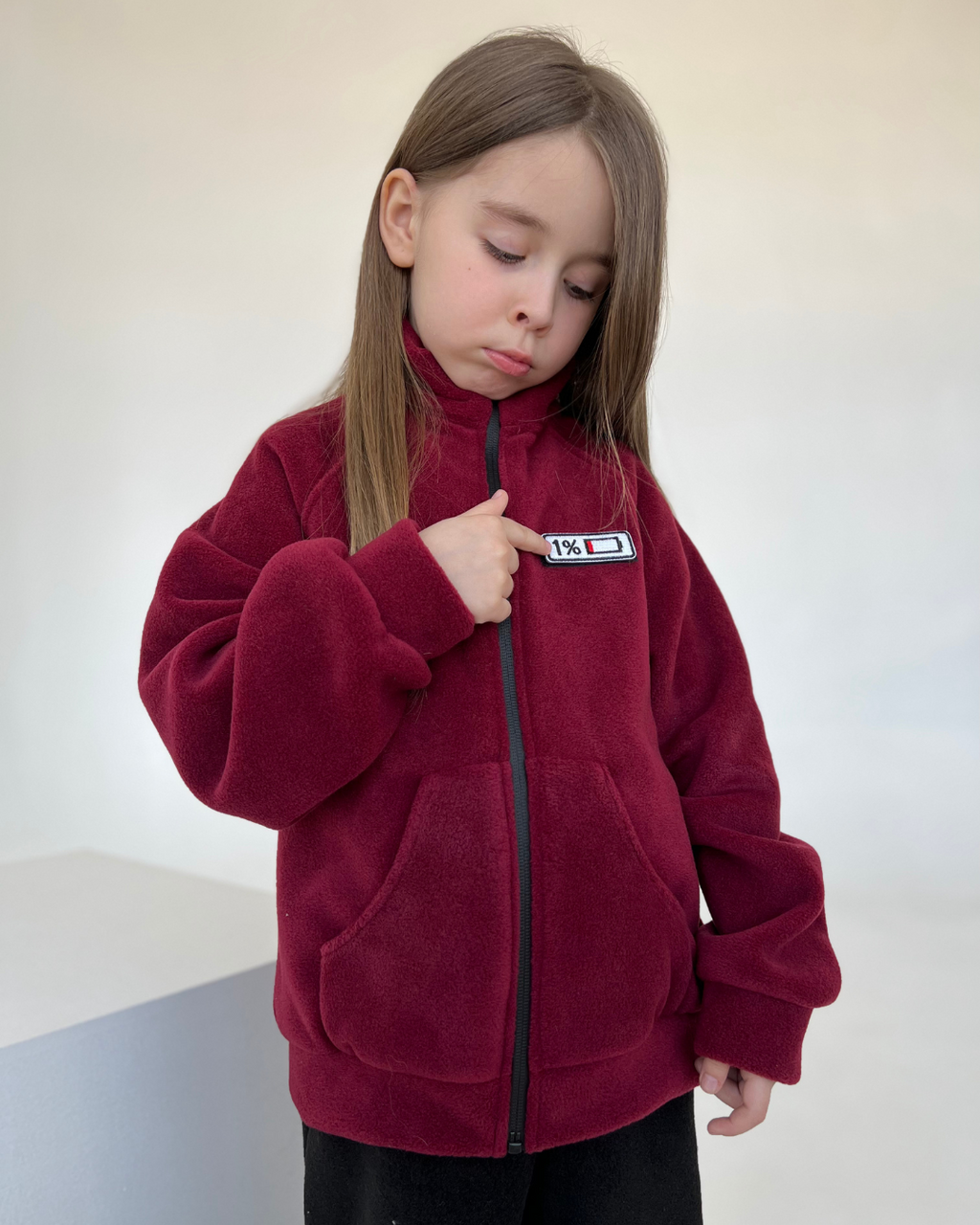 Child pointing to 1% battery mood patch on fleece jacket by Alwair Kids
