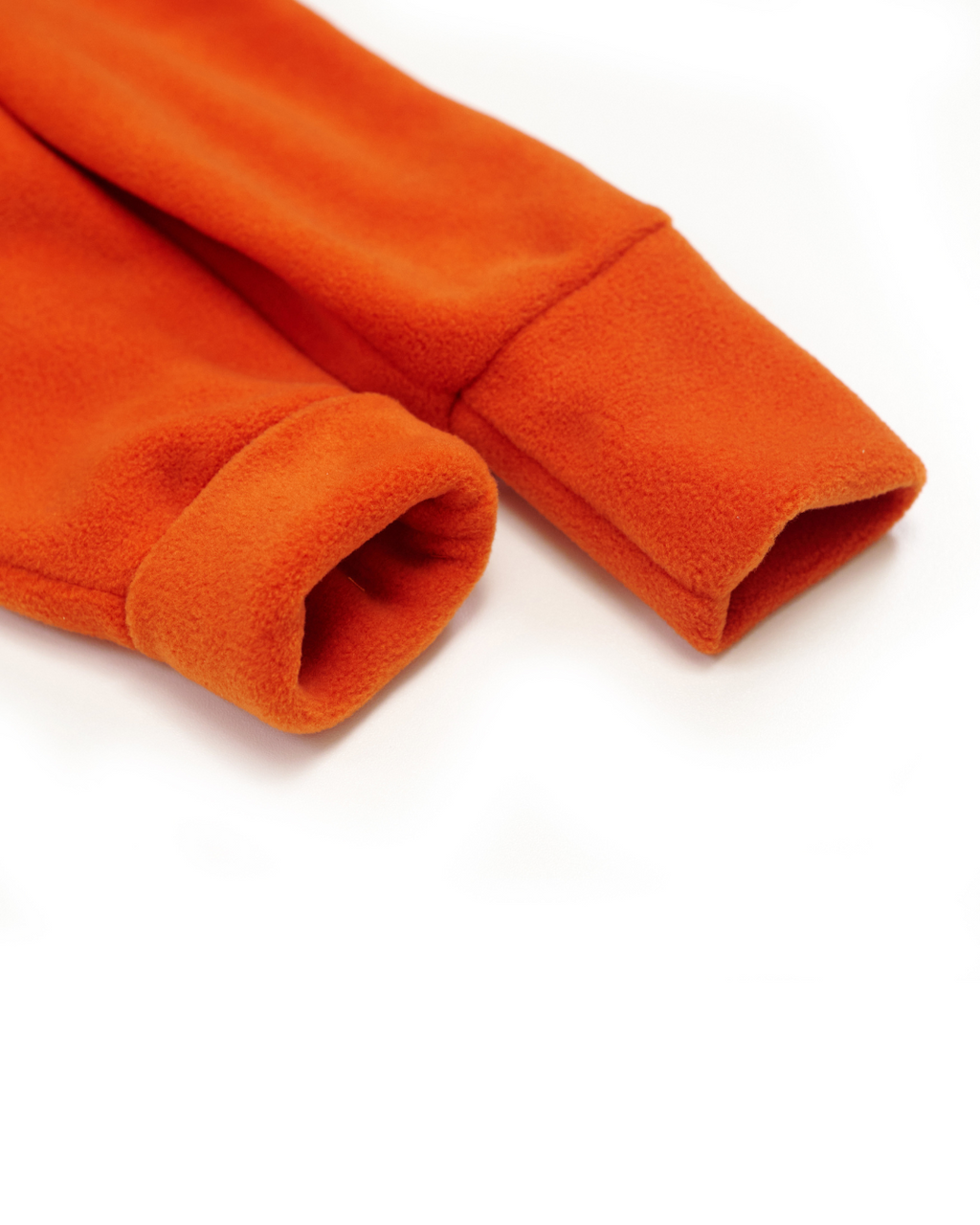 Folded fleece cuffs on orange jumpsuit – fabric close-up