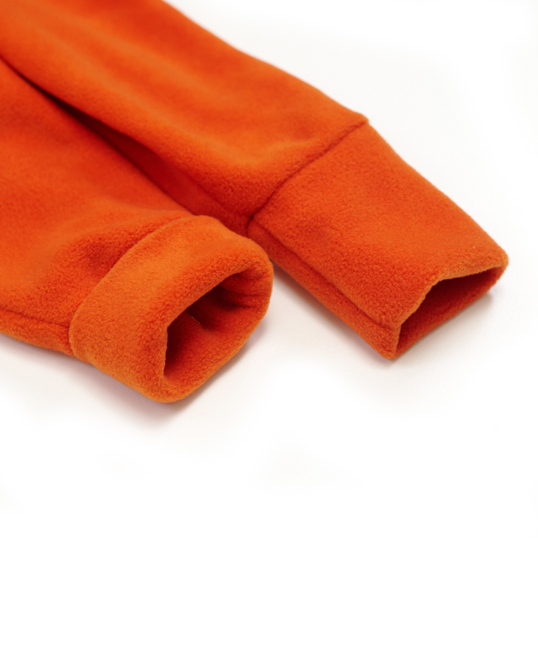Folded fleece cuffs on orange jumpsuit – fabric close-up