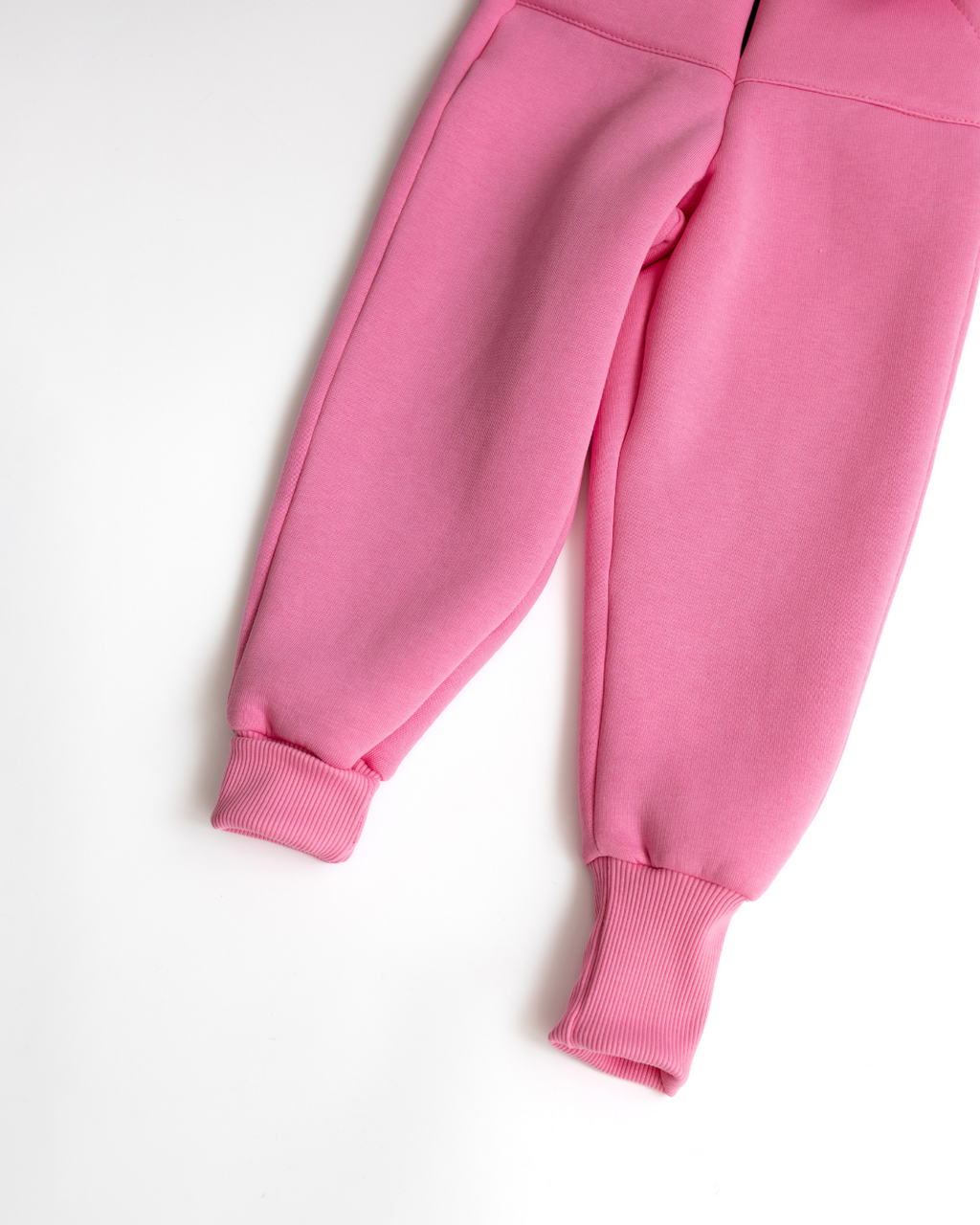Lower leg and cuffs of light pink kids fleece jumpsuit showing stretchy fit