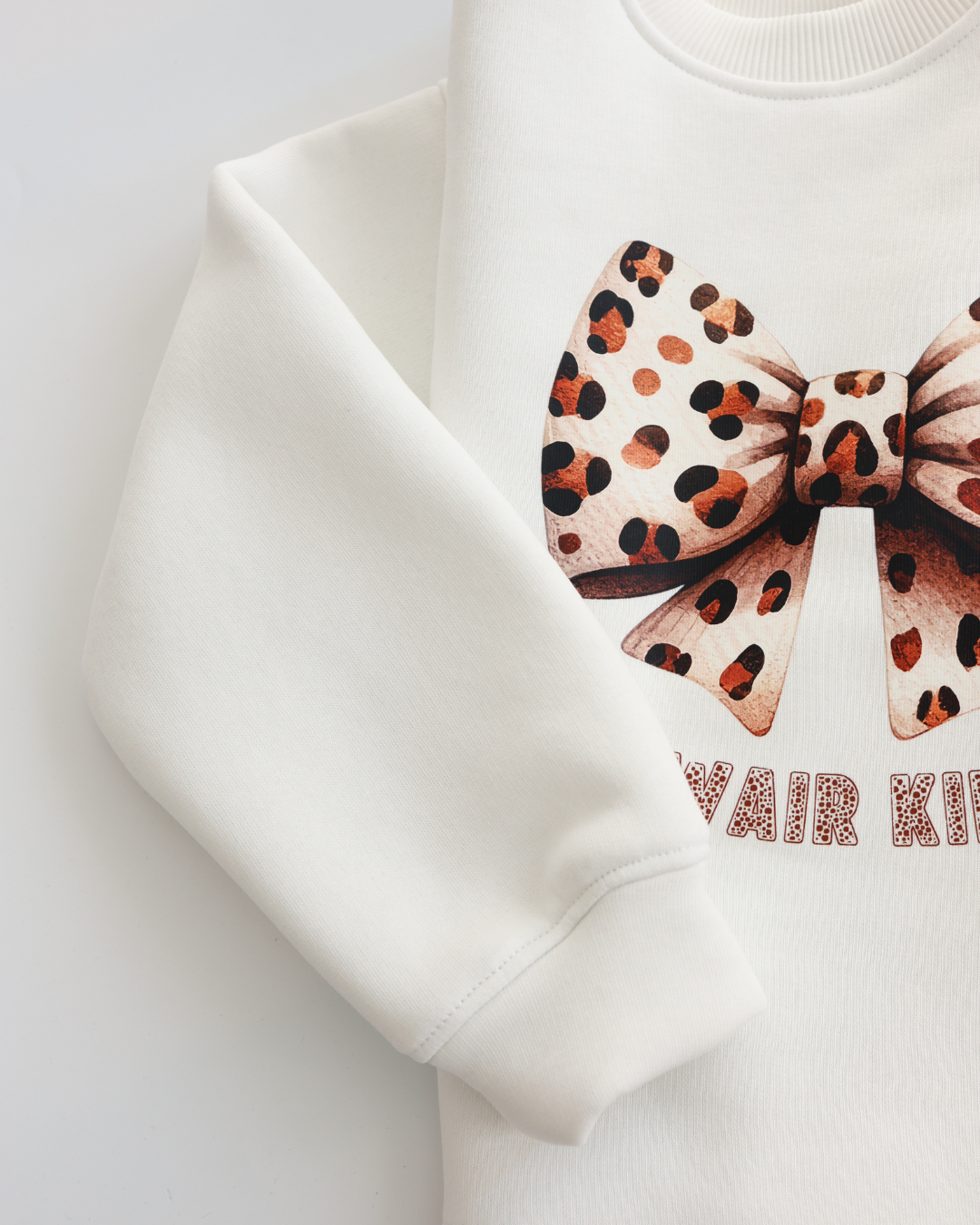 Close-up of leopard bow print and fabric texture on Alwair Kids sweatshirt