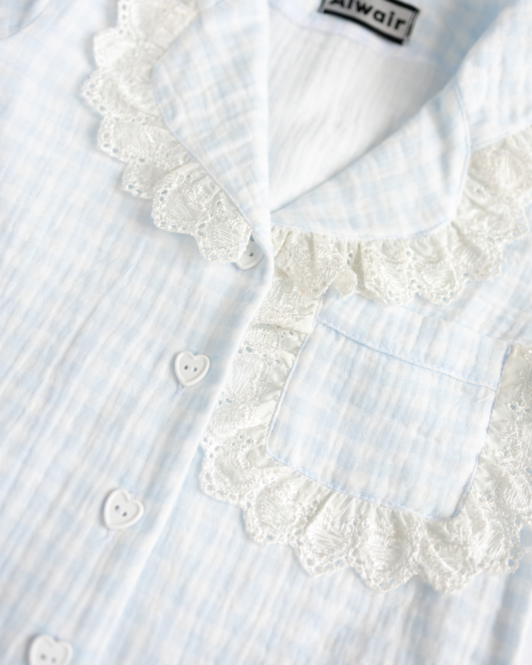 Detail of heart buttons and lace pocket on blue muslin pajama - Alwair Kids