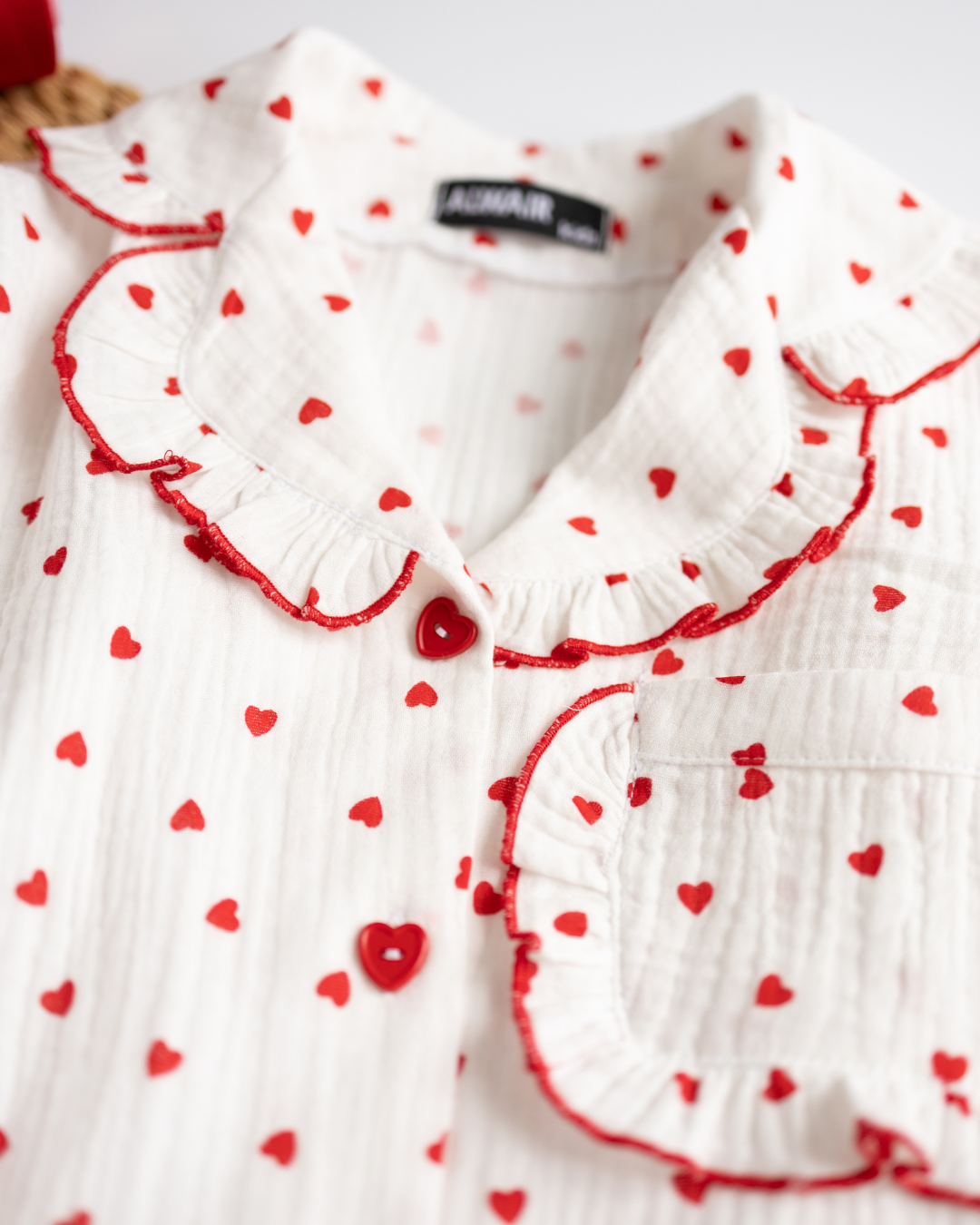 Close-up of girls' pajama collar and heart-shaped buttons with red trim