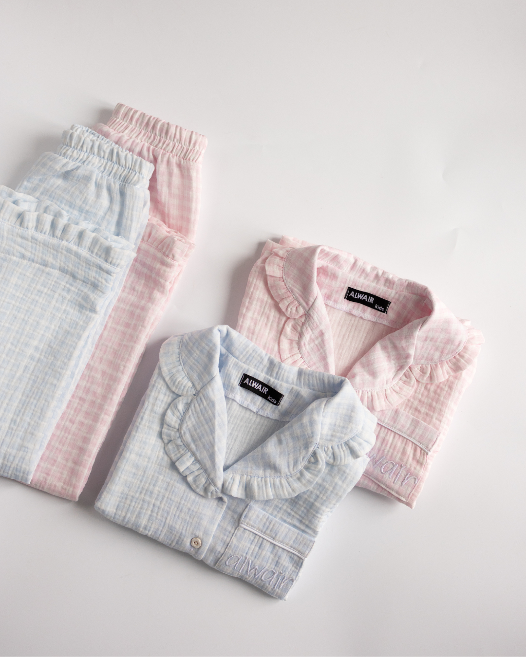 Folded girls’ pajama sets in pink and blue muslin – Alwair Kids packaging


