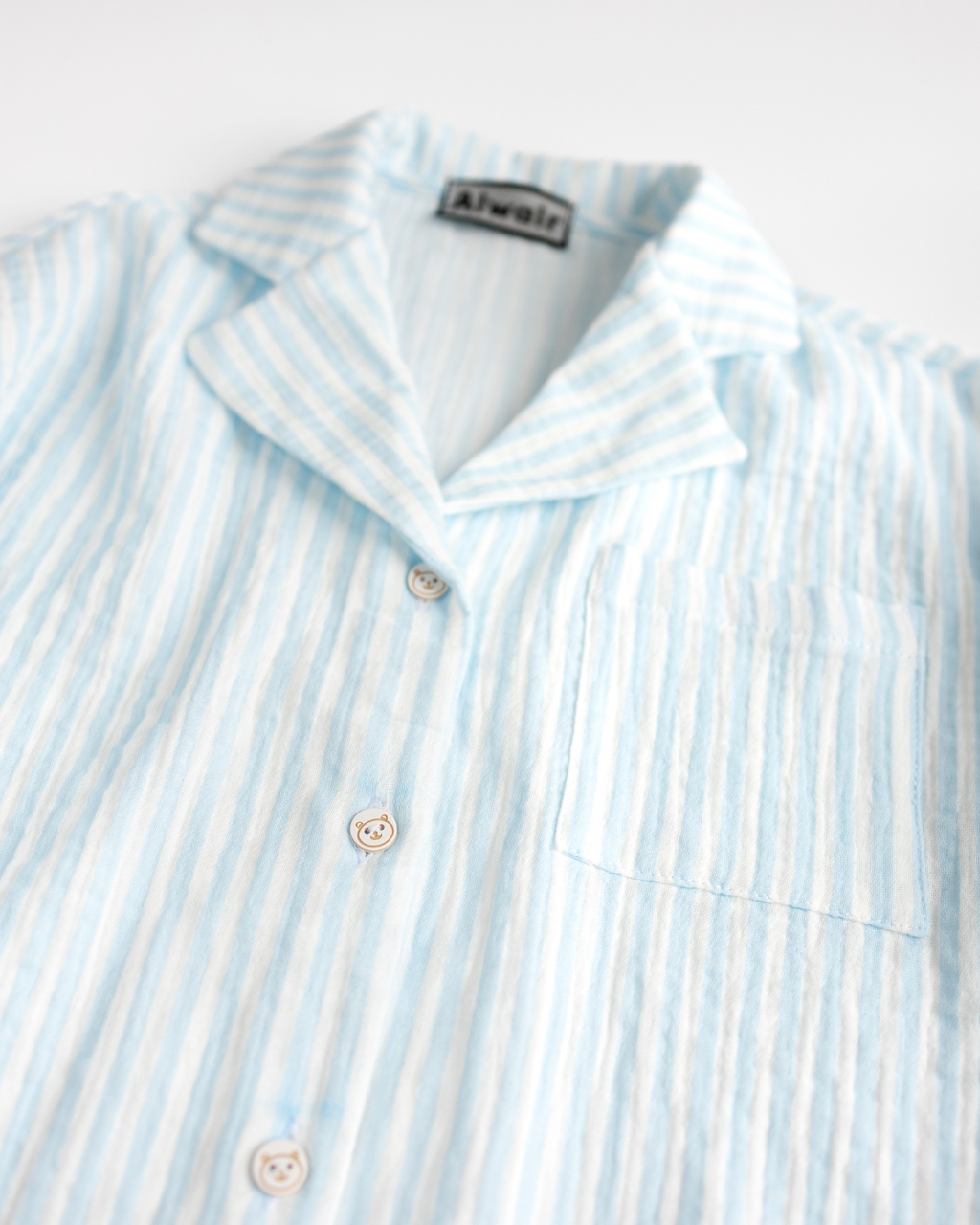 Close-up of collar and bear-shaped buttons on muslin shirt by Alwair Kids