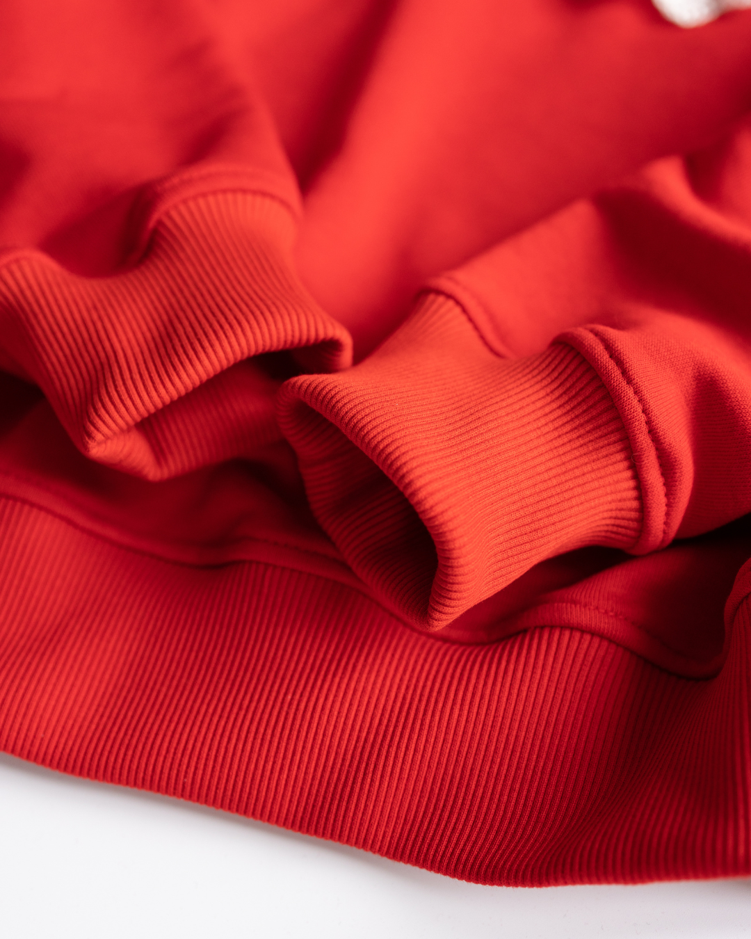 Close-up of red cotton sweatshirt cuffs and waistband