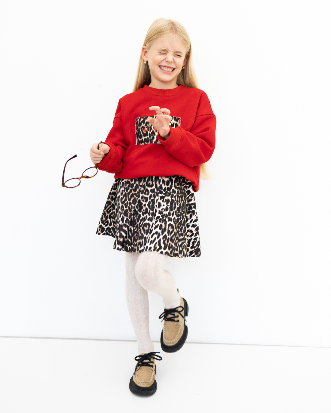 Happy girl in Alwair Kids leopard skirt laughing and playing