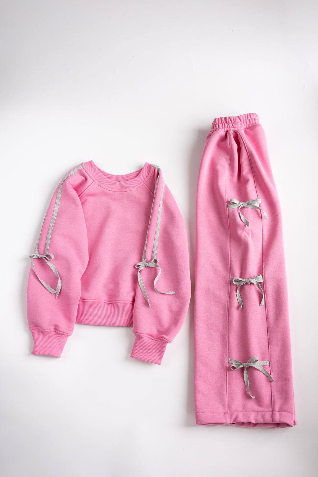 Pink and grey cotton girls tracksuit with bows flat lay