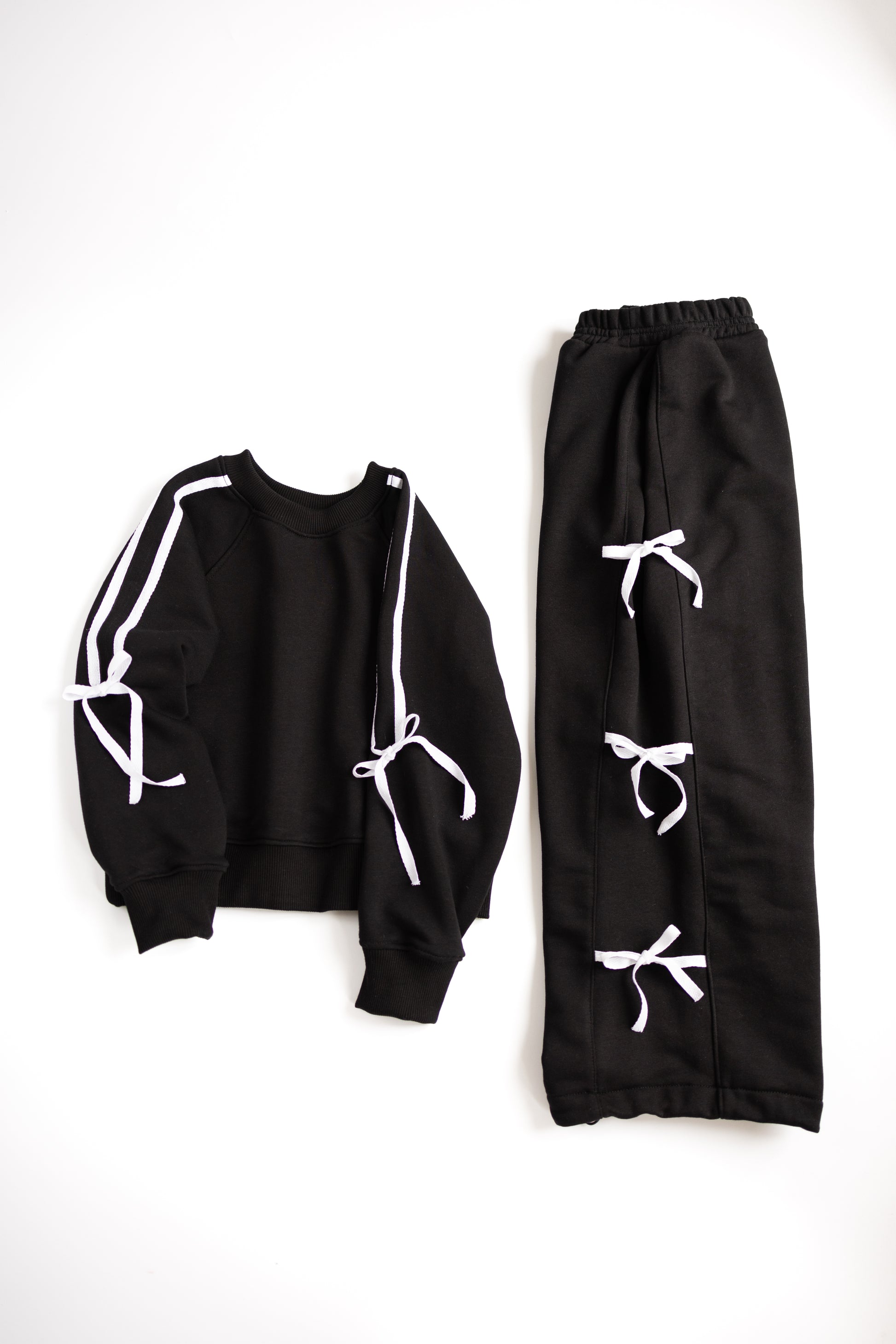 Black and white girls tracksuit with decorative bows flat lay
