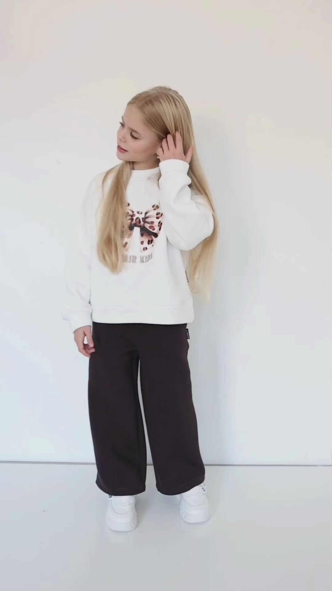 Girl wearing a leopard bow sweatshirt by Alwair Kids – stylish detail with a cozy, modern fit perfect for fall and winter outfits.