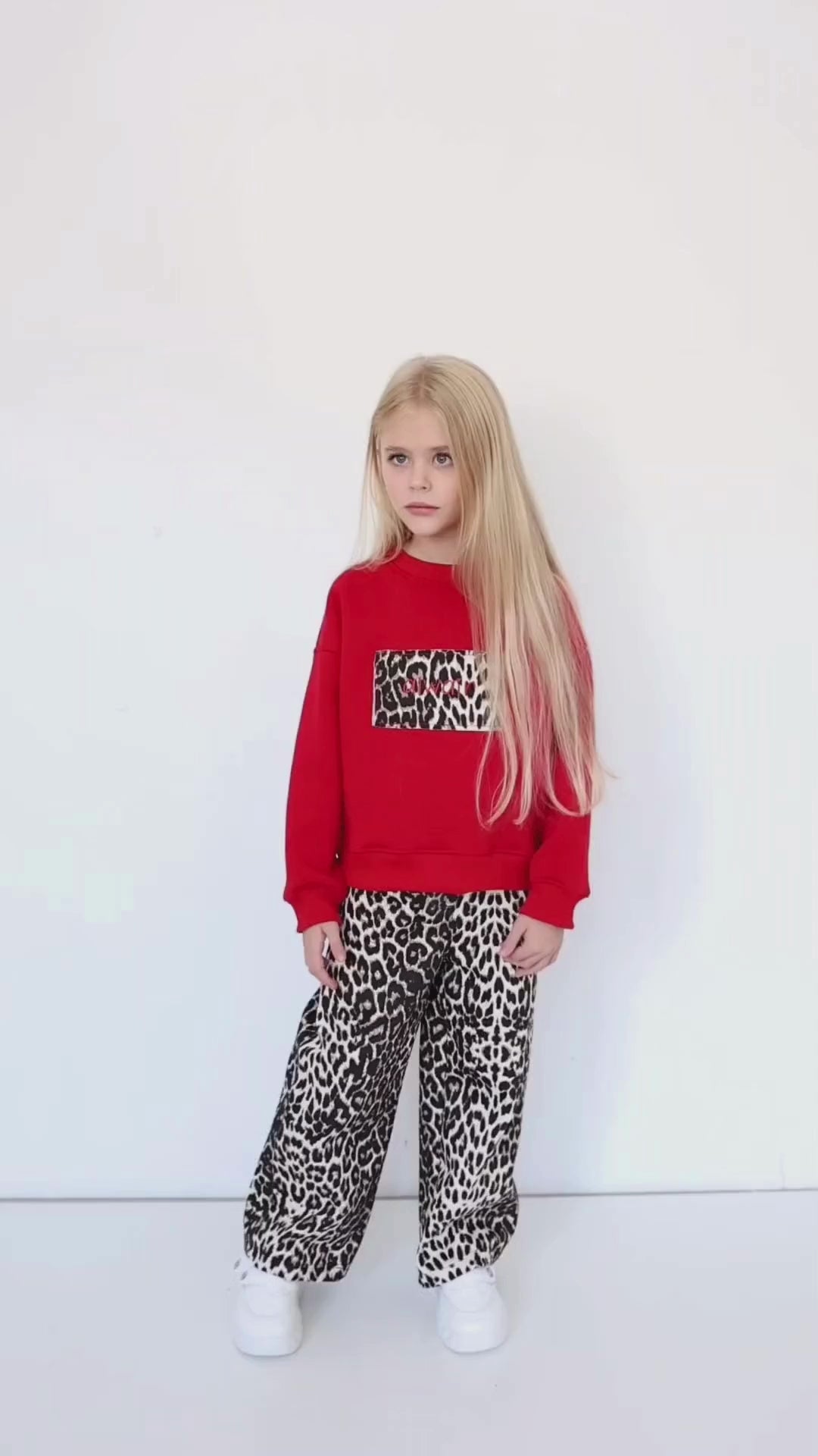 Girl wearing Alwair Kids leopard-print jeans while walking outdoors – close-up view showcasing the trendy pattern and relaxed fit.